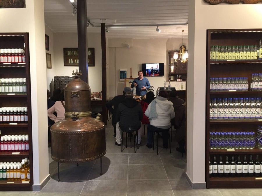 inside entrance with lockets on the both sides and tourists listening to a guide at Karonis Distillery